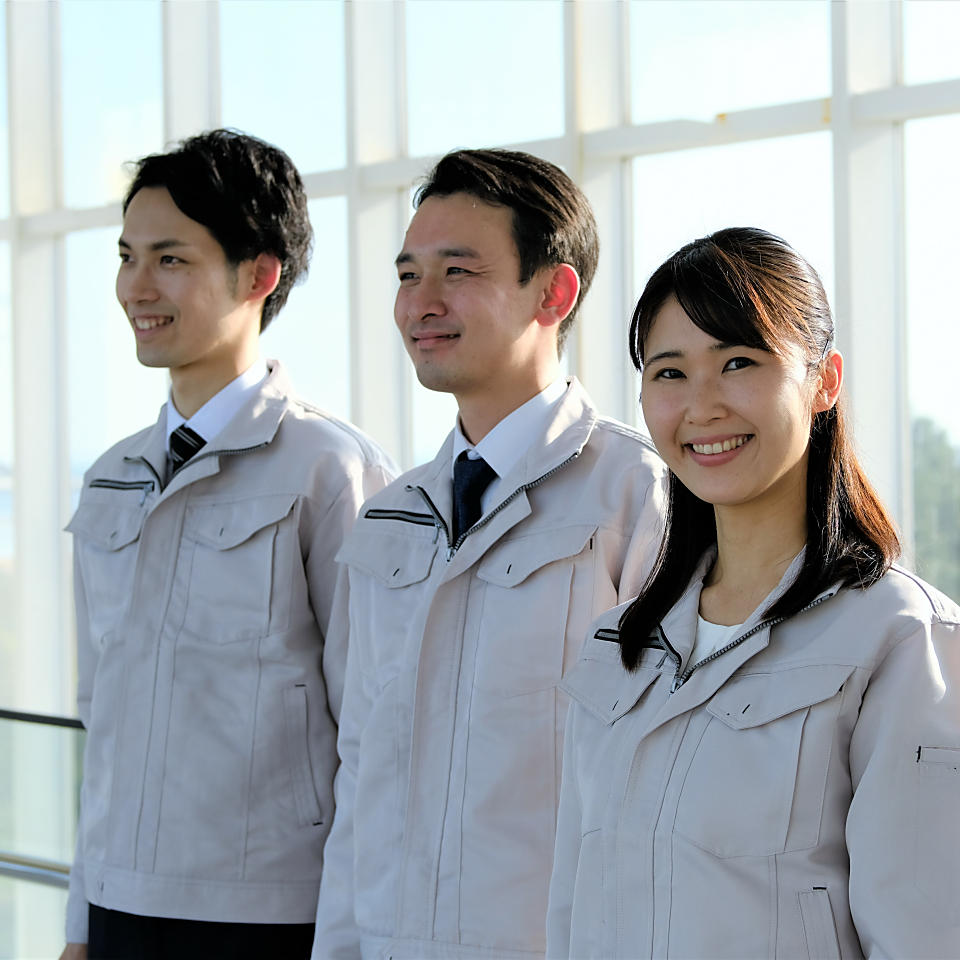 3人で並ぶ作業服の男女